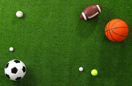 Many different sports balls on green grass, flat lay. Space for textの写真素材