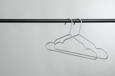 Empty clothes hangers on rack against gray background. Space for textの写真素材