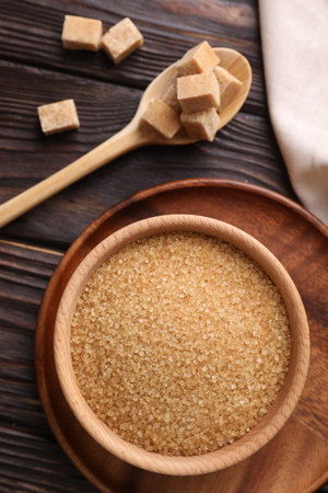 Bowl and spoon with brown sugar on wooden table, flat layの写真素材