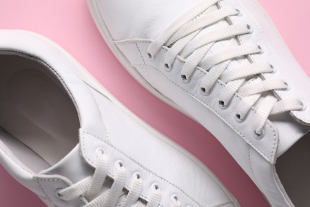 Pair of stylish white sneakers on pink background, top viewの写真素材