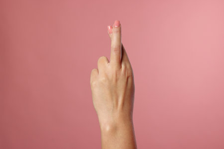 Woman crossing her fingers on pink background, closeupの写真素材