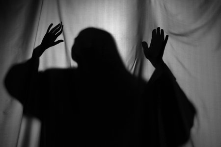 Silhouette of creepy ghost behind gray clothの写真素材