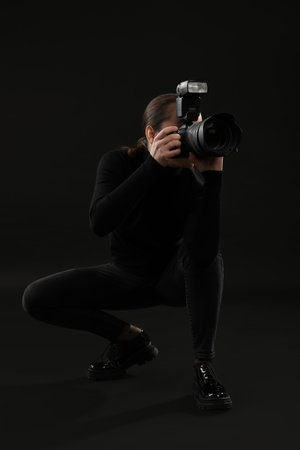 Professional photographer taking picture on black backgroundの写真素材