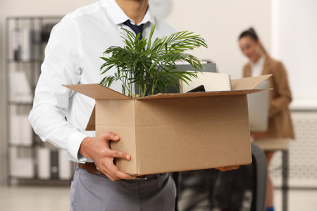 Unemployment problem. Man with box of personal belongings in office, closeupの写真素材