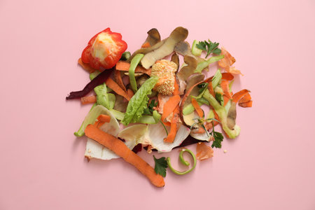 Peels of fresh vegetables on pink background, flat lay