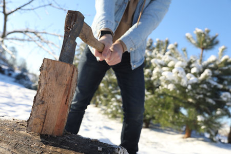 Man chopping wood with ax outdoors on winter day, closeupの写真素材