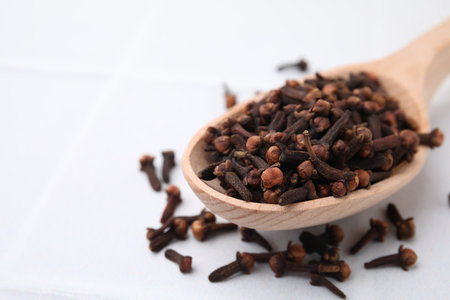 Spoon with aromatic dried clove buds on light table, closeup. Space for textの写真素材