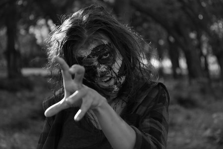 Scary zombie outdoors, black and white effect. Halloween monster