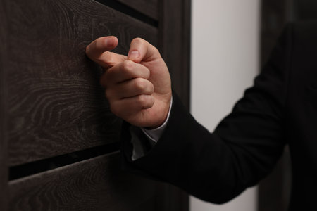 Collector knocking on door indoors, closeup viewの写真素材