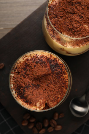 Delicious tiramisu in glasses and coffee beans on table, top viewの写真素材