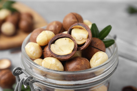 Tasty Macadamia nuts in jar on table, closeup viewの写真素材