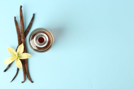 Flat lay composition with vanilla extract on light blue background. Space for textの写真素材