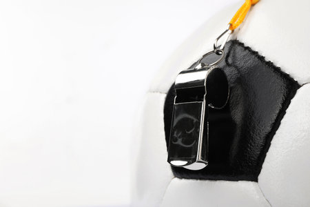Football referee equipment. Soccer ball and whistle on white backgroundの写真素材
