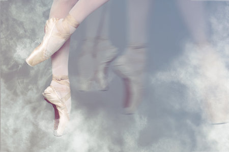 Perfection in ballet. Woman dancing in pointe shoes on gray background, closeup. Motion effect with smokeの写真素材