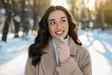 Portrait of smiling woman in winter snowy parkの写真素材