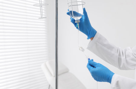 Nurse setting up IV drip in hospital, closeupの写真素材