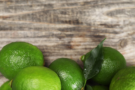 Fresh limes on wooden table, top view. Space for textの写真素材