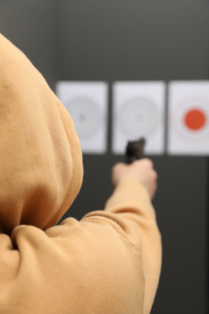 Man aiming at shooting target indoors, selective focusの写真素材