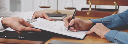 Lawyer working with client at wooden table in office, closeup. Banner designの写真素材