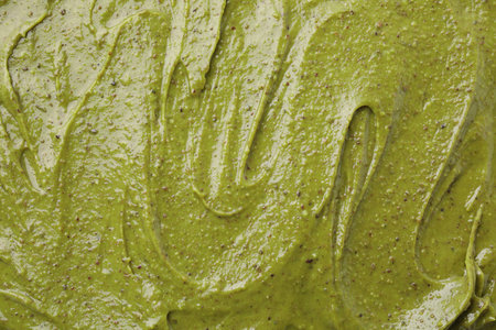 Tasty pistachio cream as background, top view