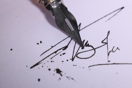 Signing on sheet of paper with fountain pen, closeup