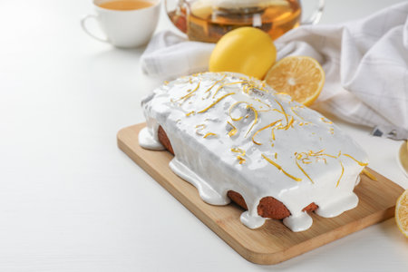 Tasty lemon cake with glaze on white table. Space for textの写真素材