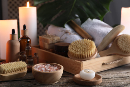 Composition with different spa products and burning candles on wooden tableの写真素材