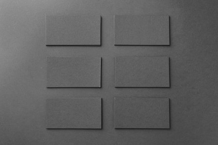 Blank business cards on black background, flat lay. Mockup for designの写真素材