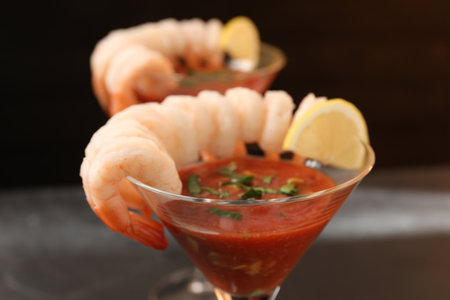 Tasty shrimp cocktail with sauce in glasses on blurred background, closeupの写真素材