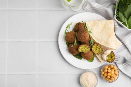 Delicious falafel balls served on white tiled table, flat lay. Space for textの写真素材