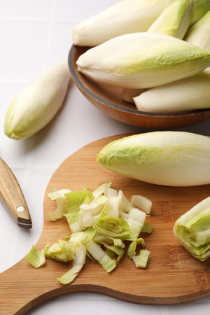 Fresh raw Belgian endives (chicory) on white tiled tableの写真素材