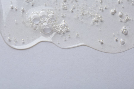 Clear cosmetic serum on white background, macro view. Space for textの写真素材