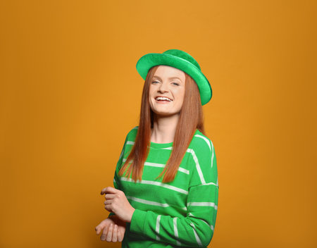 St. Patrick's day party. Pretty woman in green leprechaun hat on golden backgroundの写真素材