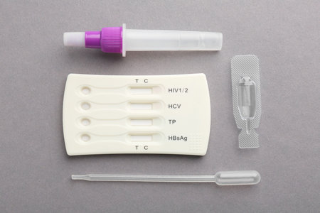 Disposable multi-infection express test kit on gray background, flat lay