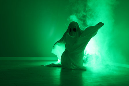 Creepy ghost. Woman covered with sheet in green light