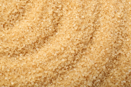 Granulated brown sugar as background, top viewの写真素材