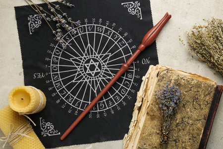 Flat lay composition with magic wand and divination cloth on light textured background