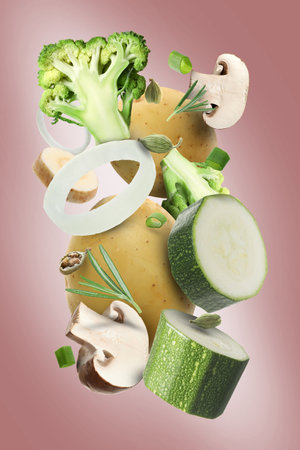 Different fresh vegetables and spices in air on dusty pink backgroundの写真素材