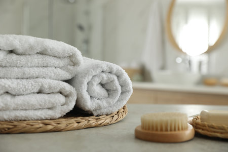 Wicker tray with clean towels on table in bathroomの写真素材