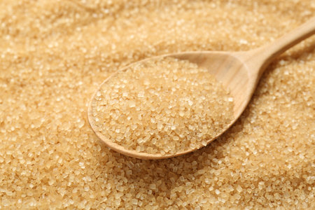 Spoon on granulated brown sugar, closeup viewの写真素材
