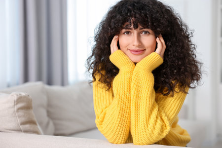 Young woman in stylish yellow sweater indoors, space for textの写真素材