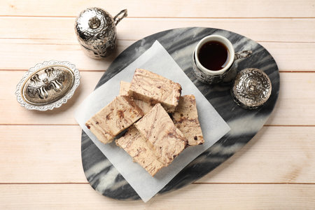 Tasty chocolate halva served on wooden table, flat lay