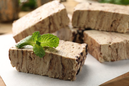 Tasty chocolate halva with mint on board, closeup