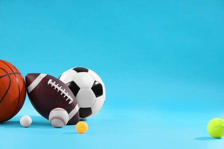 Many different sports balls on light blue background, space for textの写真素材