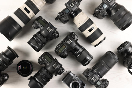 Modern cameras on white wooden table, flat layの写真素材