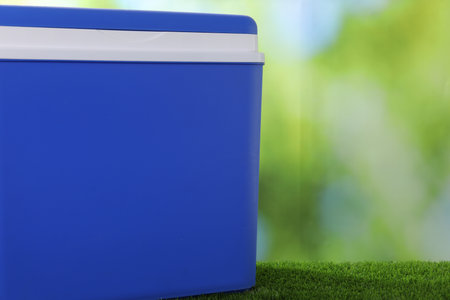 One plastic cool box on artificial grass, closeup. Space for textの写真素材