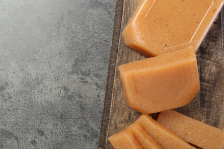 Tasty sweet quince paste on gray table, top view. Space for text