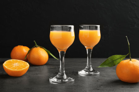 Delicious tangerine liqueur and fresh fruits on gray tableの写真素材