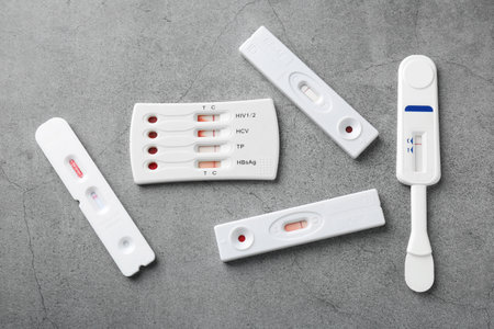 Different disposable express tests on gray table, flat lay