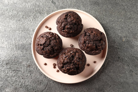 Delicious chocolate muffins on gray textured table, top viewの写真素材